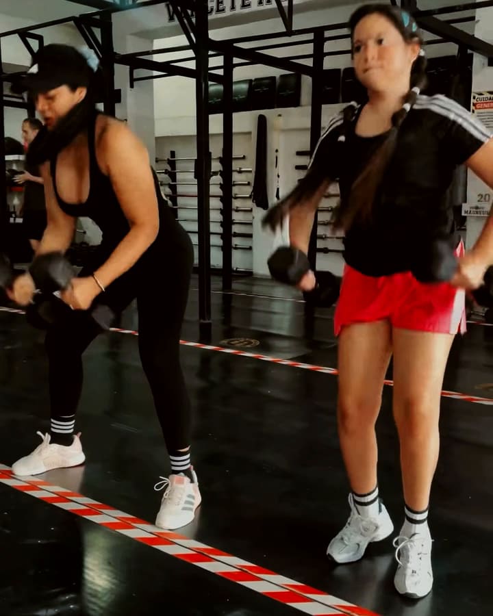 Madre e hija entrenando con mancuernas en PRO WOD